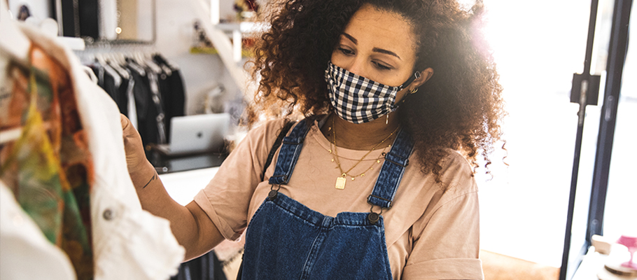 woman wearing mask shopping for clothing