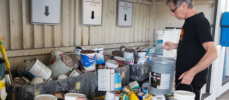 Man bringing in paint for recycling