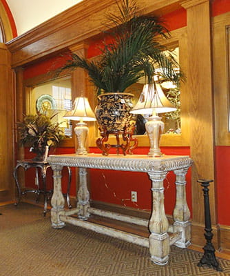 Interior of shop with red walls, a table, and lamps