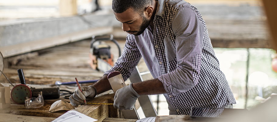 Person with earbuds working with a saw