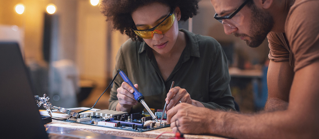 Two people repairing electronic device