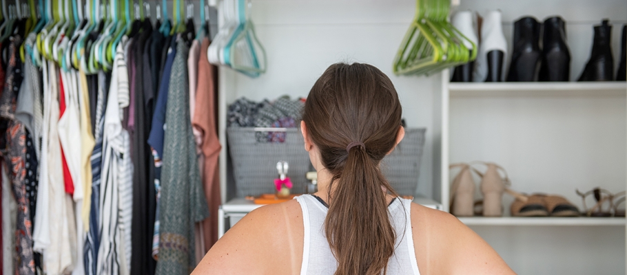 Woman facing away from viewer looking at her closet for items to donate