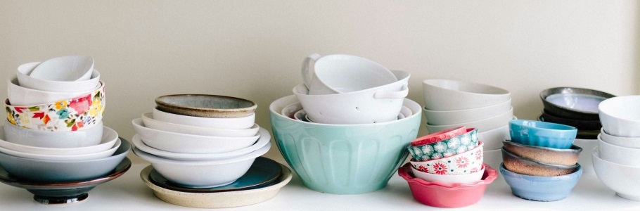 Stacks of mismatched plates and bowls from thrift store