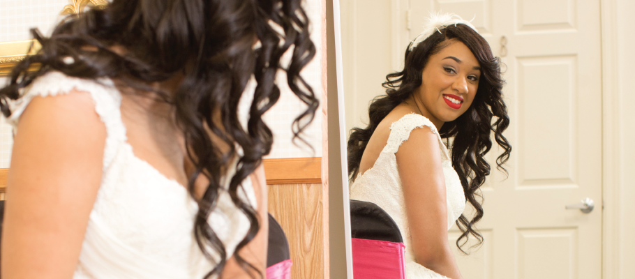 Bride in a wedding dress looking in mirror