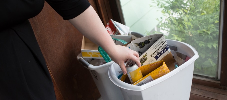 Close up of hand putting can in the recycling