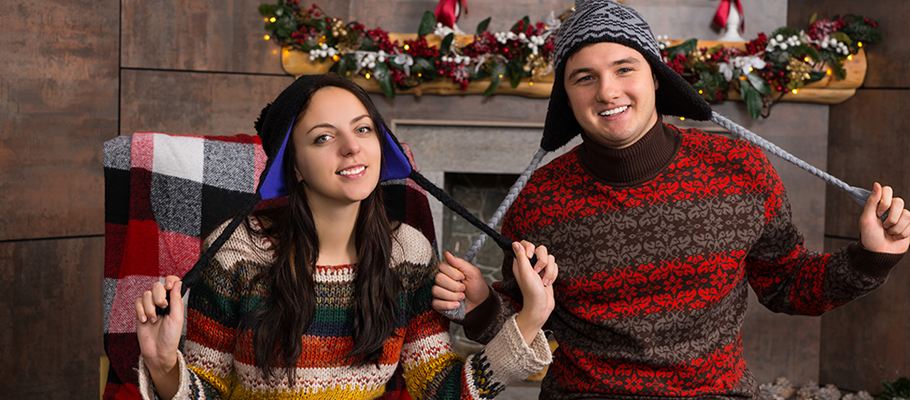 A young girl and guy wearing winter sweaters and hats