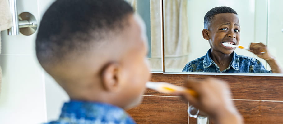 Smiling child that is brushing his teeth